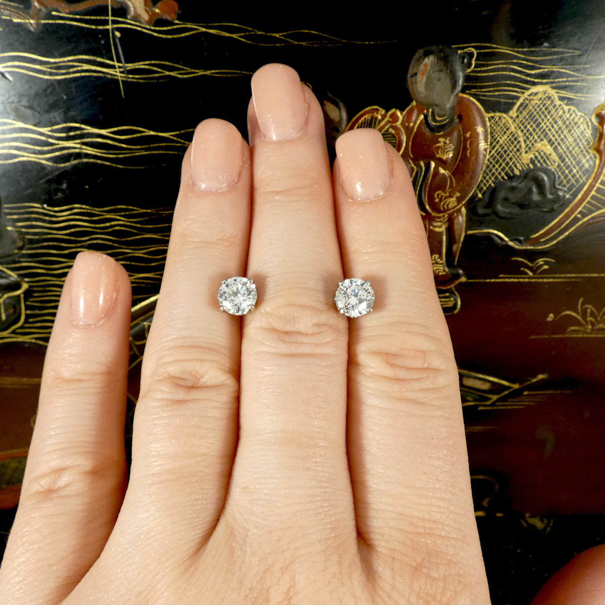 Diamond studs displayed on the hand to show their size and how large they are in context. 