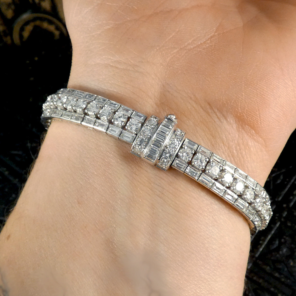 Close-up view of a 1950's French diamond bracelet highlighting the intricate details of the clasp and the dazzling arrangement of baguette and round-cut diamonds.