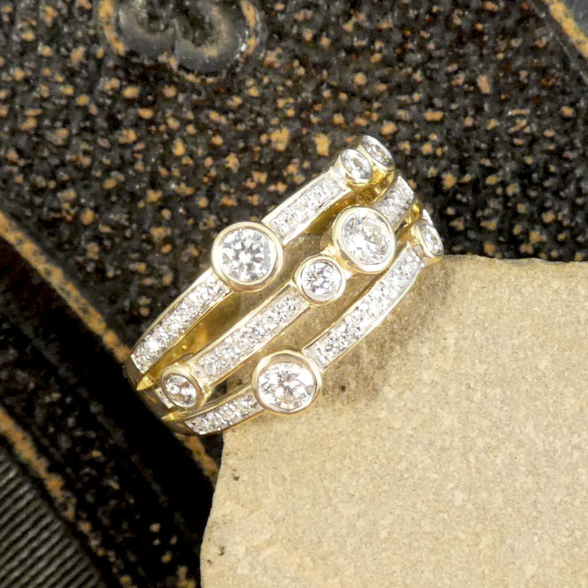 A modern bubble style diamond set ring. With larger and smaller Diamonds bezel set into three bands across a the head of the ring. A great gift idea and statement ring. All fully made in 9ct Yellow Gold with a warm beautiful aesthetic. With 0.50ct diamond weight total.