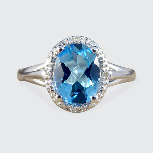 Oval Blue Topaz and Diamond Illusion Halo Cluster Ring in White Gold